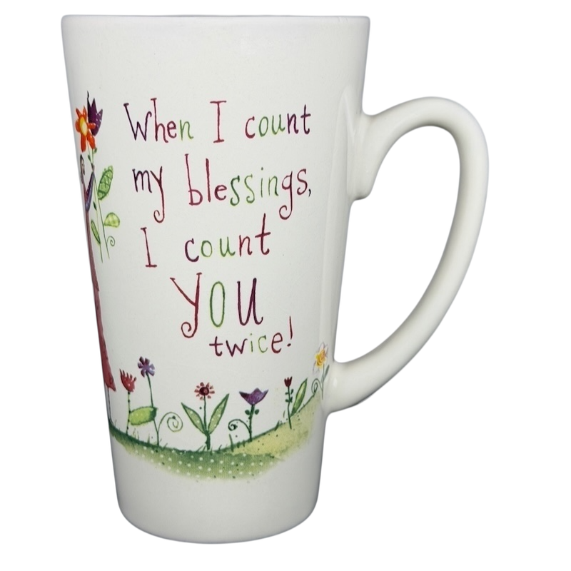 Natural Life When I Count My Blessings mug featuring colorful flowers and an uplifting message
