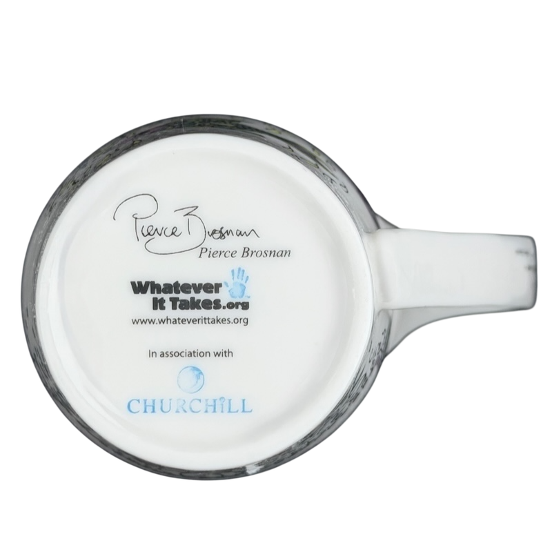 Bottom view of Pierce Brosnan Whatever It Takes mug showing logo and signature on a ceramic surface