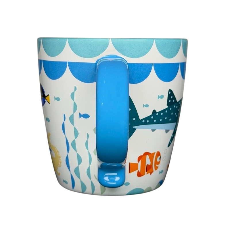 Finding Dory Mug Pixar Disney Store featuring colorful ocean graphics and a blue handle