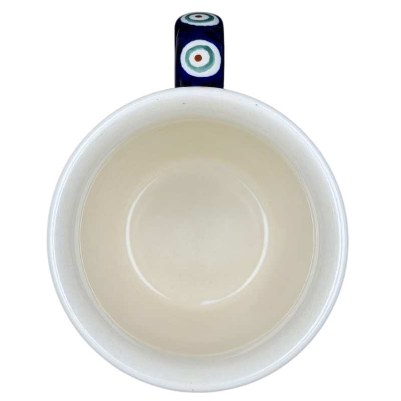 Inside view of a Polish pottery blue peacock eye mug showcasing its smooth surface and vibrant handle design