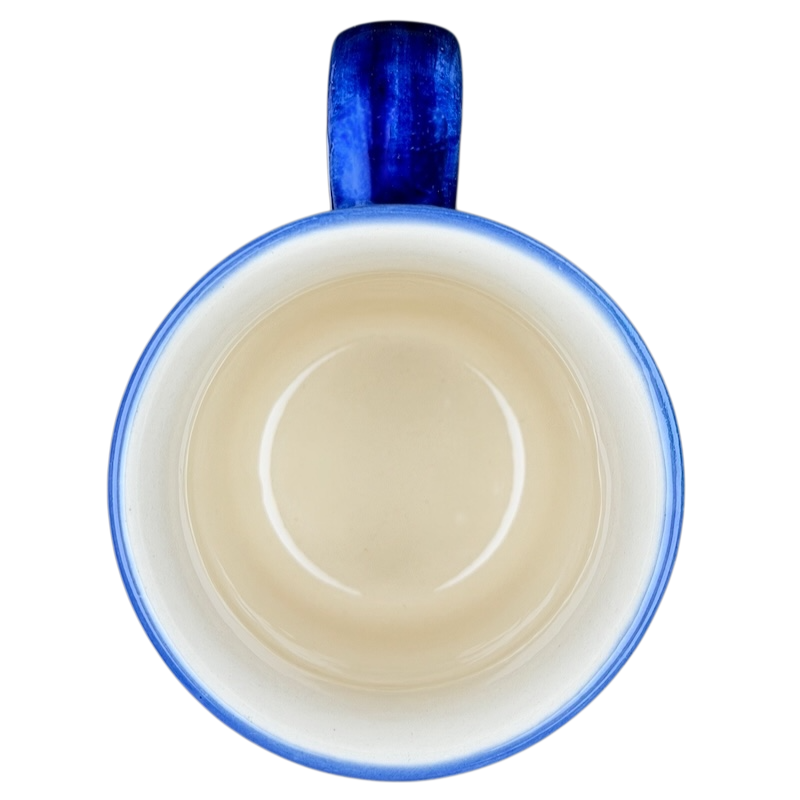 Polish Pottery Red Floral and Peacock Eye Boleslawiec mug with a blue handle and smooth beige interior