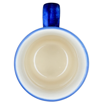 Polish Pottery Red Floral and Peacock Eye Boleslawiec mug with a blue handle and smooth beige interior