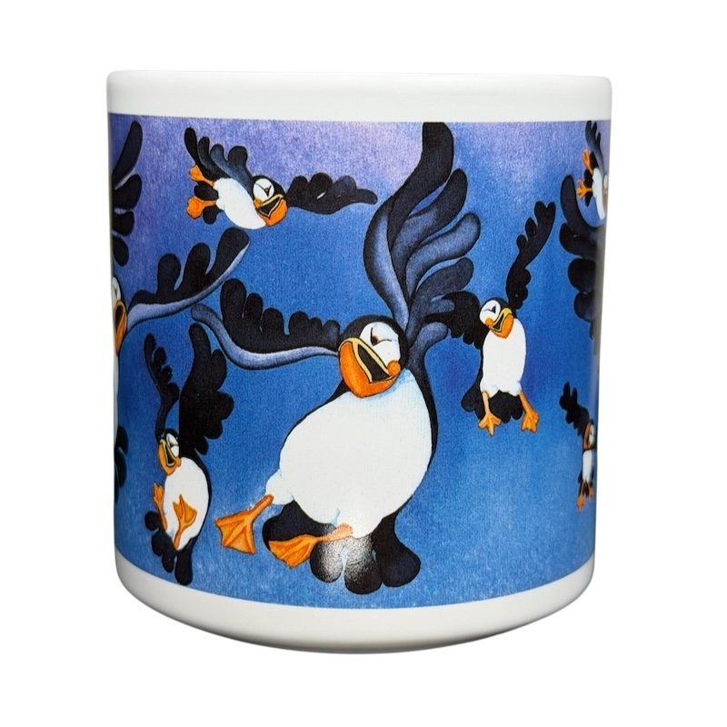Puffins Barbara Lavallee Mug Arctic Circle Enterprises featuring colorful flying puffins on a blue background