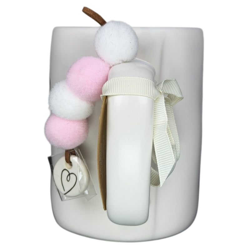 Rae Dunn MAMA Mug Magenta with pastel pom pom decoration and a ribbon bow for stylish beverage enjoyment