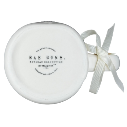 Bottom view of Rae Dunn Merry and Bright collectible mug with decorative ribbon and logo