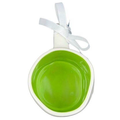 Rae Dunn Toy Story Alien Pixar Disney mug with a bright green interior and a decorative ribbon