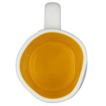 Top view of Rae Dunn Toy Story Woody Pixar Disney mug with vibrant yellow interior and white exterior