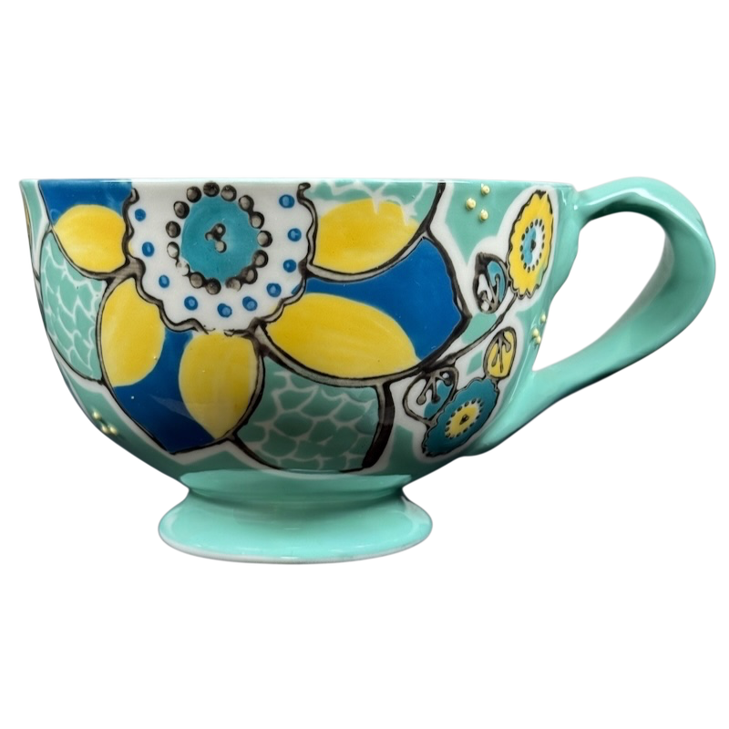 Anthropologie Elka Ayaka green floral pedestal mug with turquoise handle and yellow blue hand painted flowers