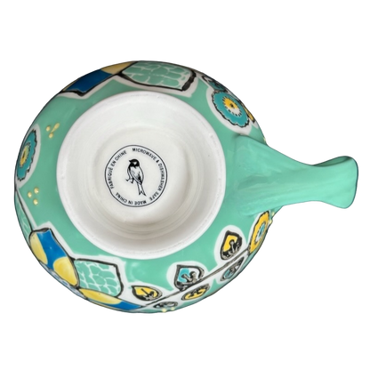 Top view of Anthropologie Elka Ayaka green floral pedestal mug showing mint green floral pattern and interior maker stamp