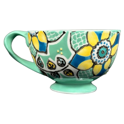 Anthropologie Elka Ayaka green floral pedestal mug with yellow and blue flower pattern on mint base