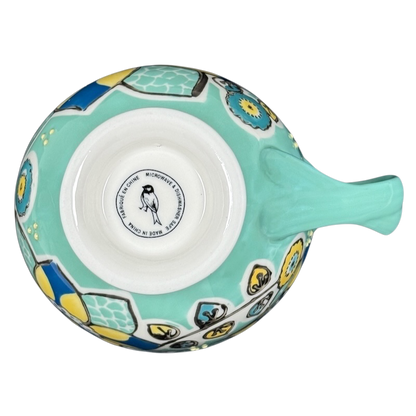 Top view of Anthropologie Elka Ayaka green floral pedestal mug showing turquoise handle and yellow blue floral pattern