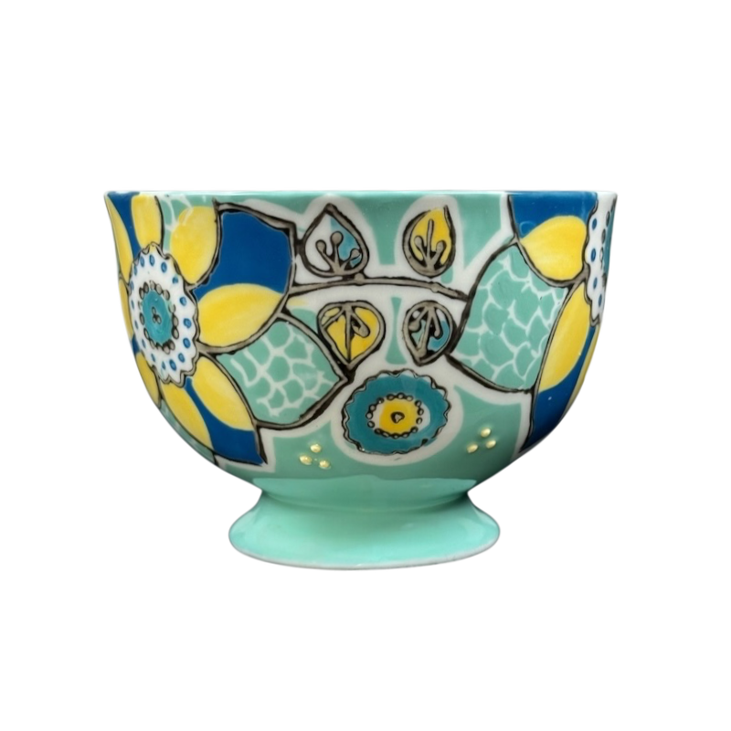 Anthropologie Elka Ayaka green floral pedestal mug with turquoise base and bold yellow and blue flower motifs