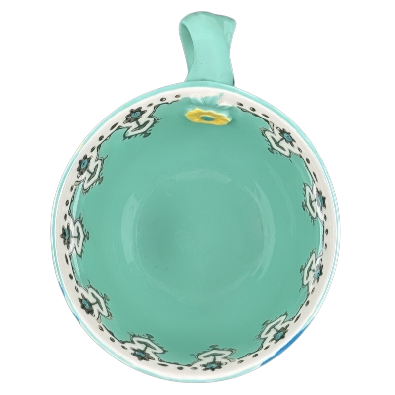 Top view Anthropologie Elka Ayaka green floral pedestal mug turquoise interior with white floral border and handle