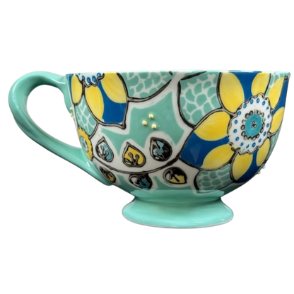 Anthropologie Elka Ayaka green floral pedestal mug with yellow blue flower pattern and gold dot accents