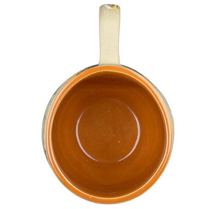 Top view of a Sleeping Beauty hand-painted pottery mug with a vibrant orange interior