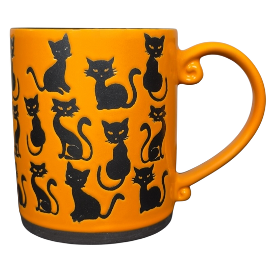 Collectible Spectrum Designz black cats mug with bright orange ceramic body and repeating black cat silhouettes