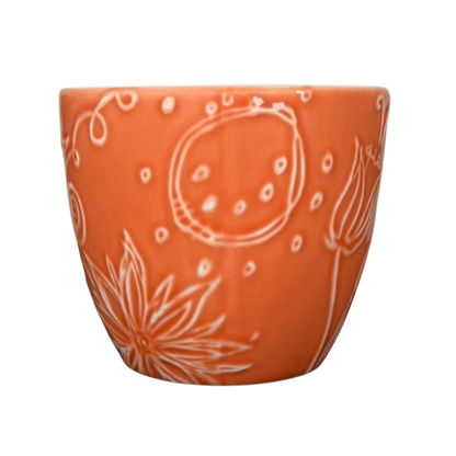 2006 Starbucks embossed coral flowers leaves mug with intricate floral designs and a vibrant coral color
