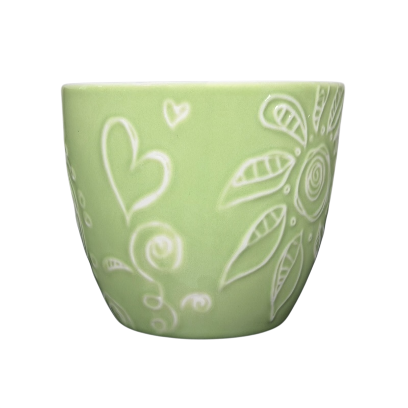 2006 Starbucks embossed green flowers hearts mug showcasing decorative designs on a pastel green background