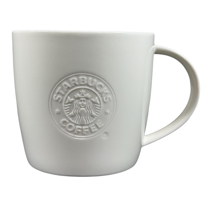 White ceramic 2009 Starbucks vintage embossed siren logo mug with raised siren emblem and rounded handle