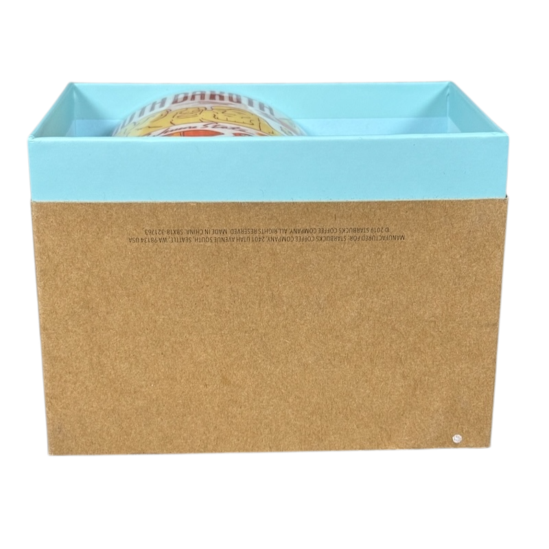 2018 Starbucks South Dakota Collectible mug partially visible inside blue and brown packaging box