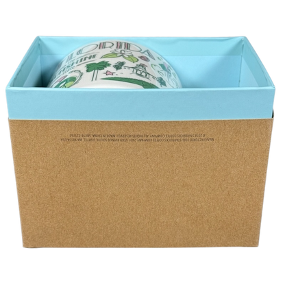 Starbucks Florida Been There mug partially visible inside blue and brown gift box on black background