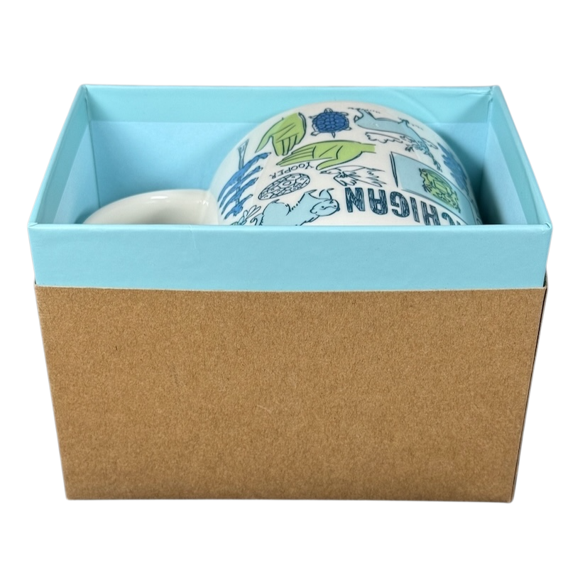Starbucks Michigan Been There mug in blue and white with state-themed illustrations inside a light blue and brown gift box