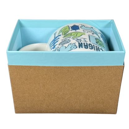 Starbucks Michigan Been There mug in blue and white with state-themed illustrations inside a light blue and brown gift box