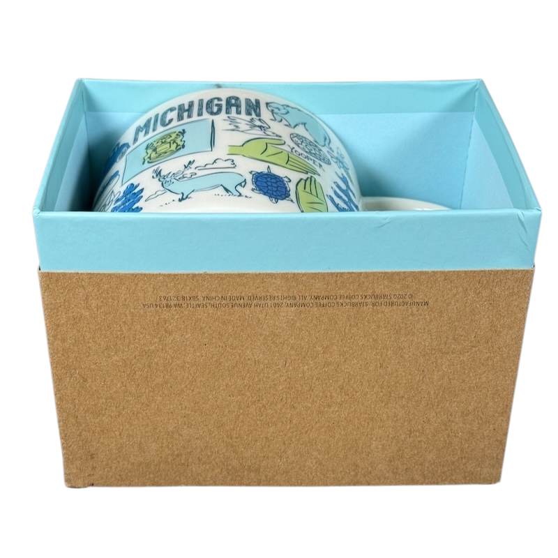 Starbucks Michigan Been There mug in blue and white with state illustrations partially visible in a blue and brown gift box