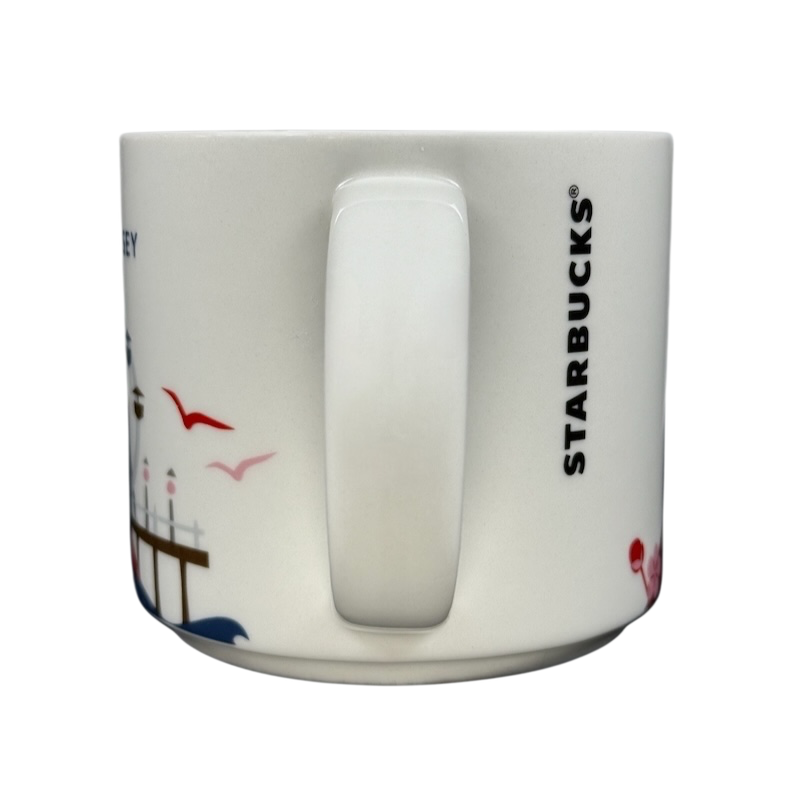 Starbucks New Jersey You Are Here collectible mug side view with handle coastal pier seagulls and vertical Starbucks logo