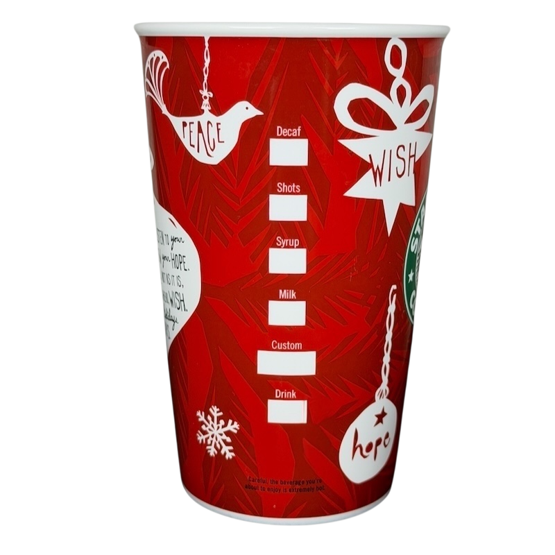 Vintage 2009 Starbucks holiday mug with festive red design featuring wish and peace symbols