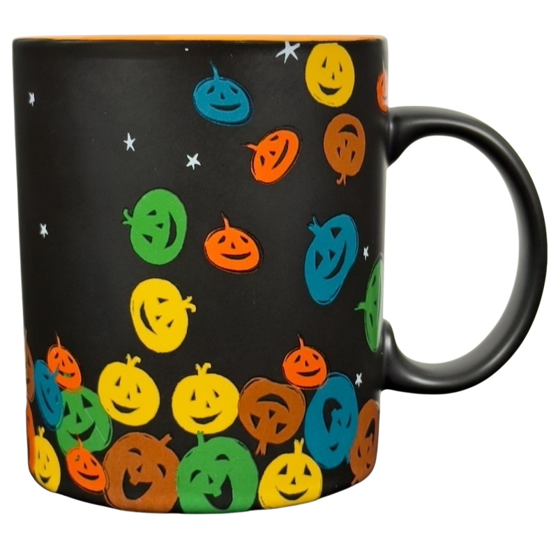 Black ceramic vintage Starbucks Halloween pumpkin mug with colorful smiling jack o lantern faces and handle