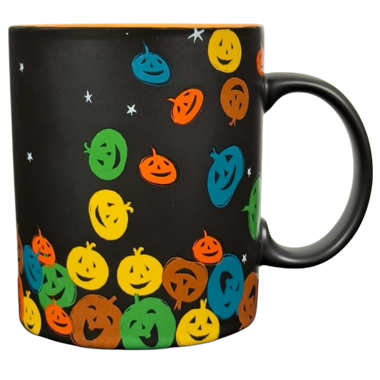 Black ceramic vintage Starbucks Halloween pumpkin mug with colorful smiling jack o lantern faces and handle