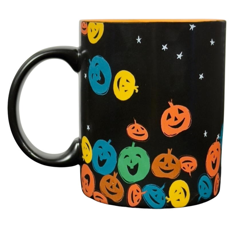 Black ceramic vintage Starbucks Halloween pumpkin mug with colorful smiling jack o lanterns and star accents
