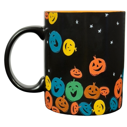 Black ceramic vintage Starbucks Halloween pumpkin mug with colorful smiling jack o lanterns and star accents