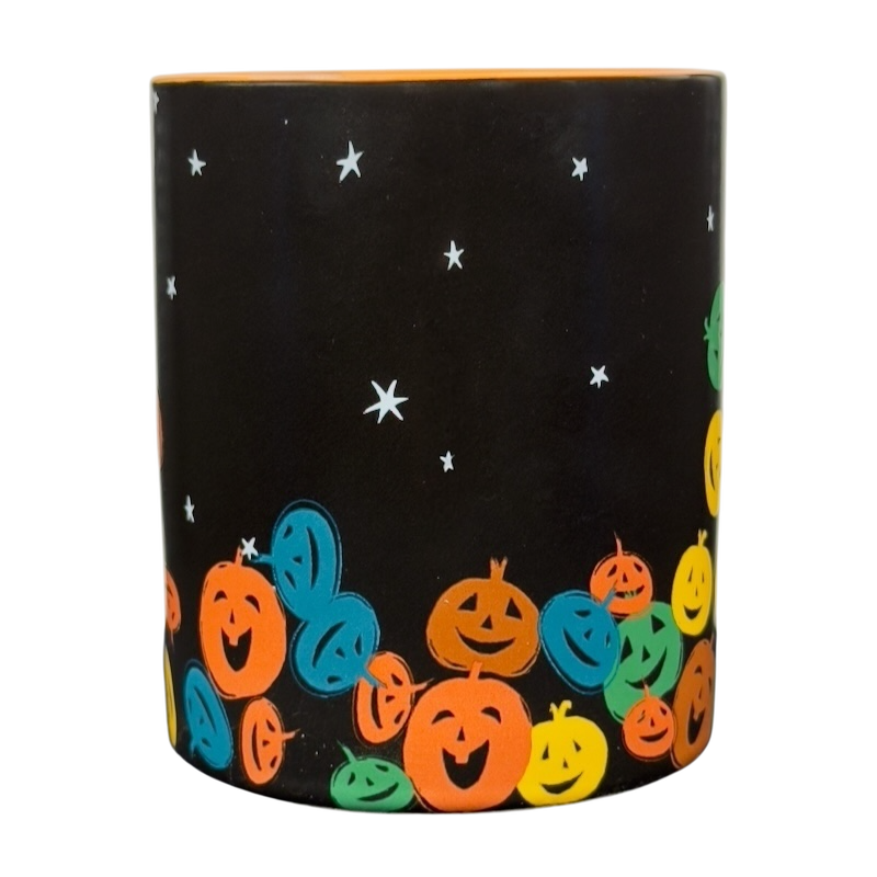 vintage Starbucks Halloween pumpkin mug with black background and colorful smiling jack o lanterns