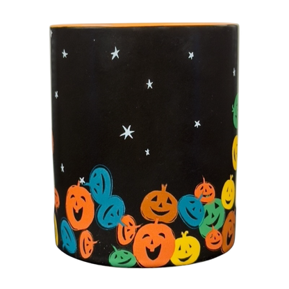 vintage Starbucks Halloween pumpkin mug with black background and colorful smiling jack o lanterns