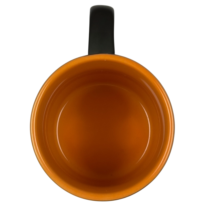 Top view of vintage Starbucks Halloween pumpkin mug orange glazed interior with black handle empty ceramic cup
