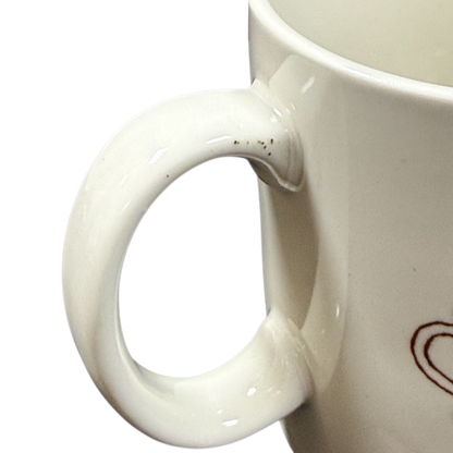 Close up of white ceramic handle and partial heart motif on black background Taylor & Ng Le Chat vintage mug