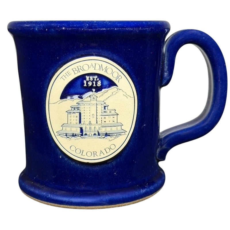 The Broadmoor Colorado Pottery Mug in blue featuring the historic hotel design and established date 1918