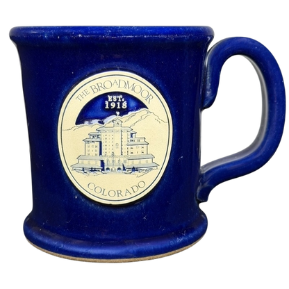 The Broadmoor Colorado Pottery Mug in blue featuring the historic hotel design and established date 1918