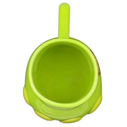 Top view of The Good Dinosaur Arlo Spot mug featuring a bright green design and round body