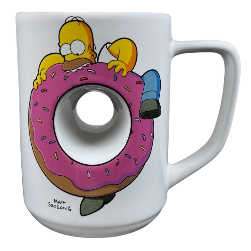 The Simpsons Homer Universal Studios donut mug featuring Homer Simpson holding a large pink donut