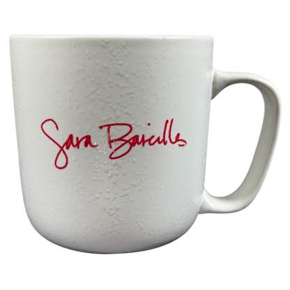 White textured ceramic Sara Bareilles tour mug with red signature script and right handle