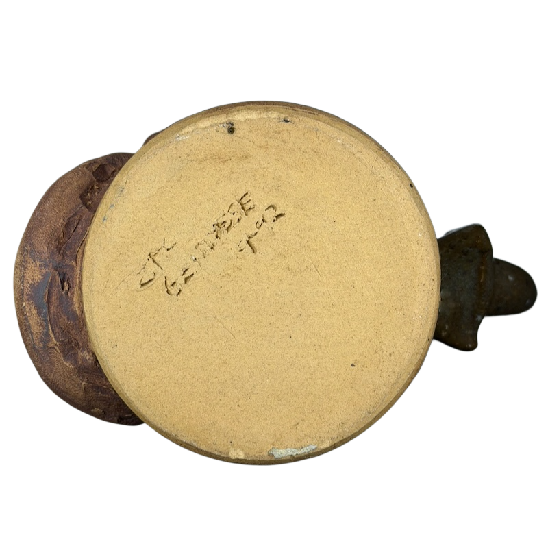 Bottom view of an ugly face pottery golf mug showing the unique texture and design details