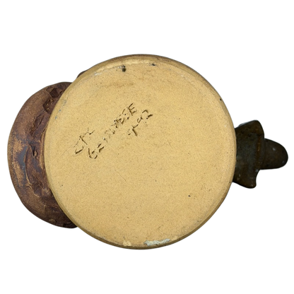 Bottom view of an ugly face pottery golf mug showing the unique texture and design details