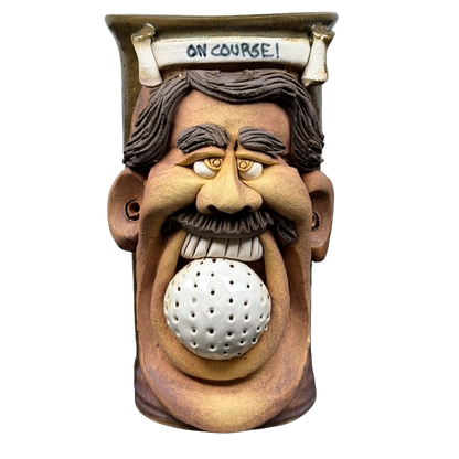 Ugly face pottery golf mug featuring a smiling man's face with a golf ball in his mouth