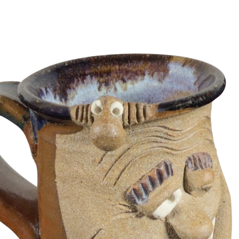 Ugly face pottery vintage winking mug with textured ceramic and playful facial expression