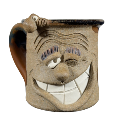 Ugly face pottery vintage winking mug with a large grin and textured ceramic design
