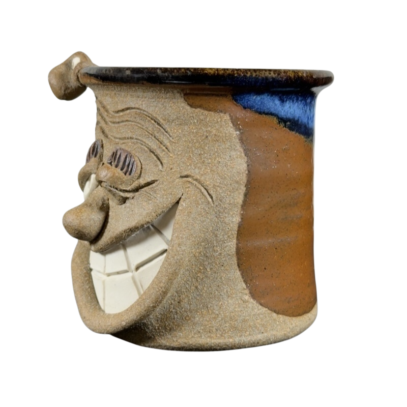 Ugly face pottery vintage winking mug with textured brown and blue glaze and a smiling face design