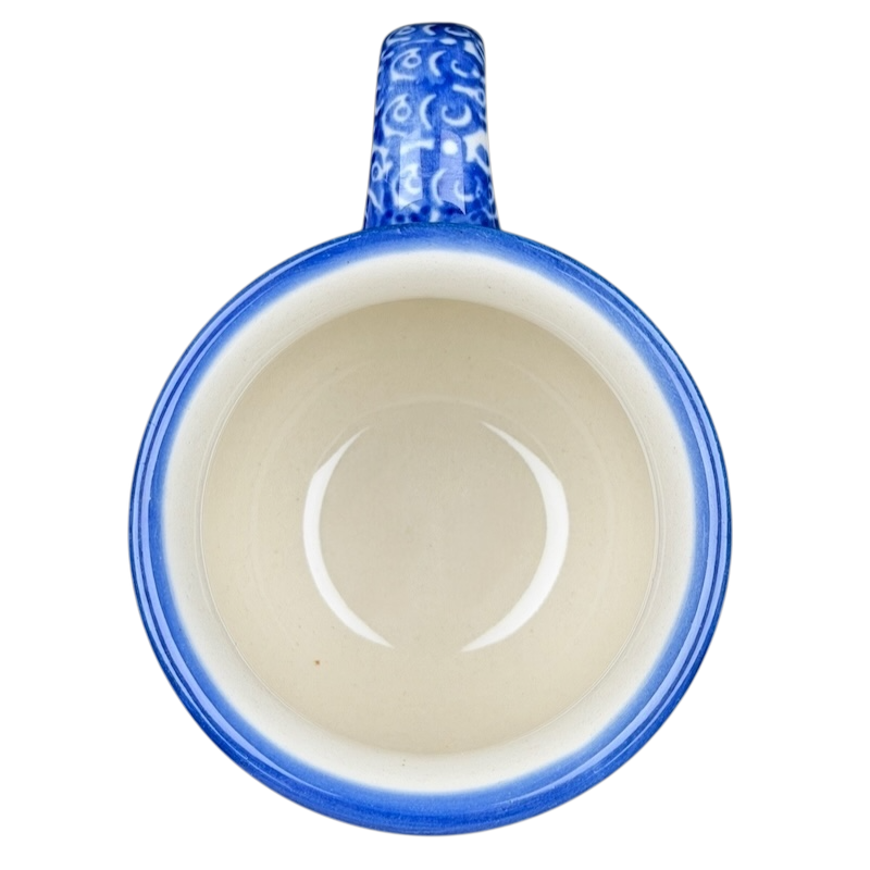 Unikat Polish pottery Boleslawiec mug with a blue handle and intricate design inside